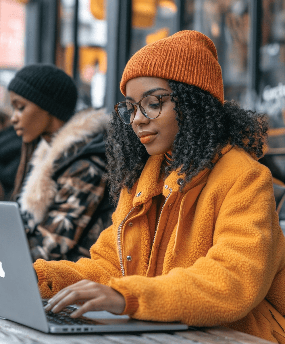 Donkere vrouw met beanie die werkt op een laptop aan fomo
